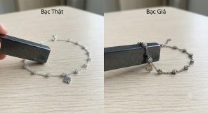 Mẹo phân biệt lắc chân bạc thật và bạc giả bằng cách sử dụng thanh nam châm.