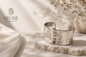 Mẫu lắc tay nữ bản lớn thiết kế tối giản tinh tế từ thương hiệu Muse Accessories đặt trên bệ đá trang trí.